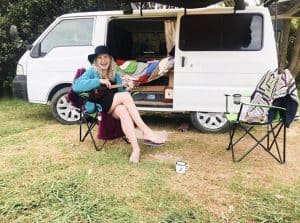 a photo of me sitting in front of my campervan while van living full time for 3 months around New Zealand