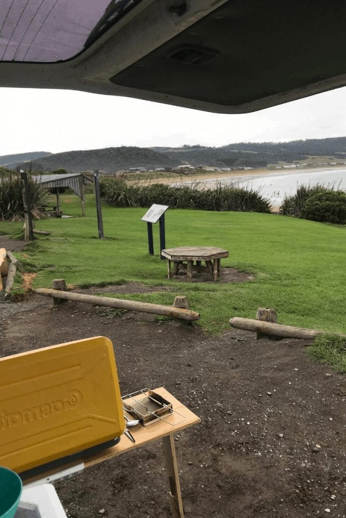 camping is one of the best things to do in the catlins and this photo is of me having lunch looking over curio bay 