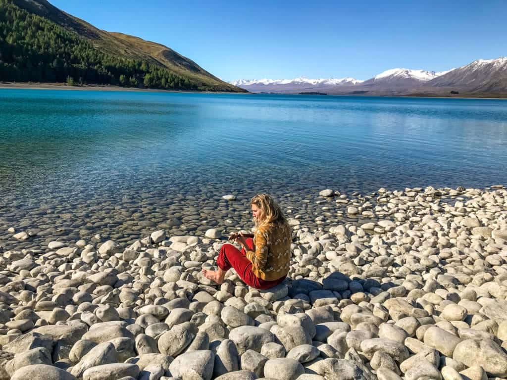this is a photo of me playing ukelele in front of lake tekapo a typical destination on a south island road trip 